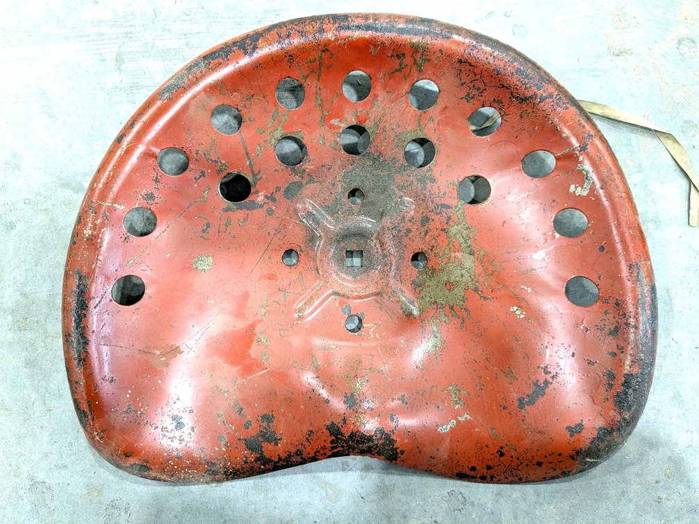 Rustic stamped steel tractor seat is 17" wide.
