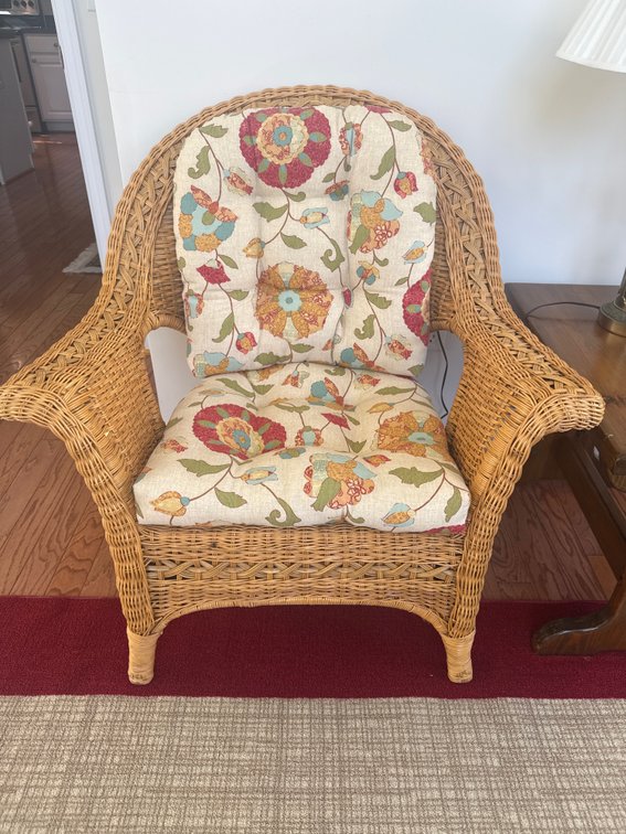 Woven Wicker Armchair with Floral Cushions and Accent Pillow