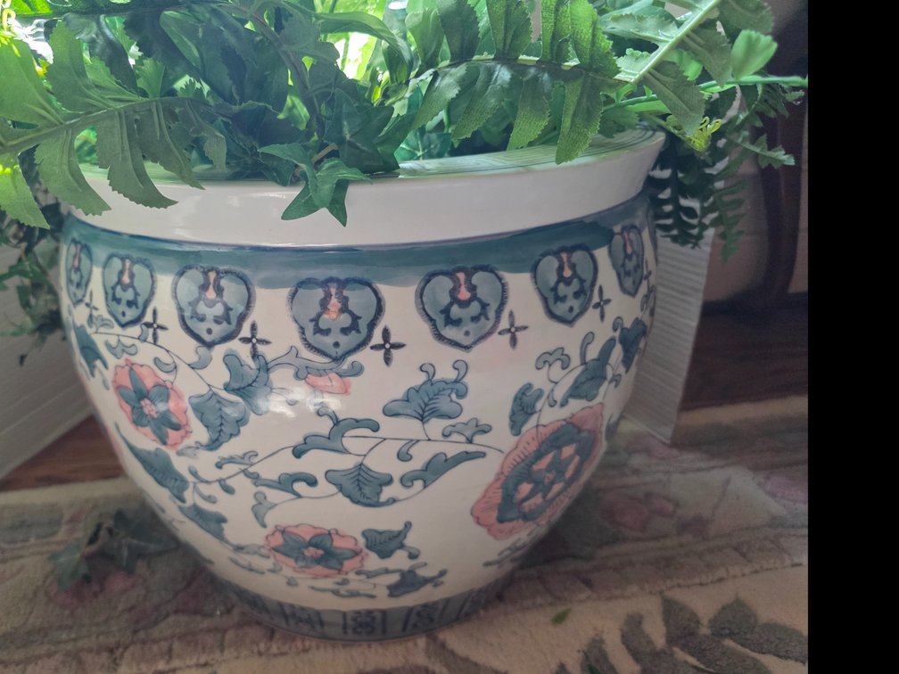 Chinese-style porcelain fish bowl planter, also known as a jardiniere or cachepot, featuring a white glaze decorated with blue and pink floral and foliage motifs.