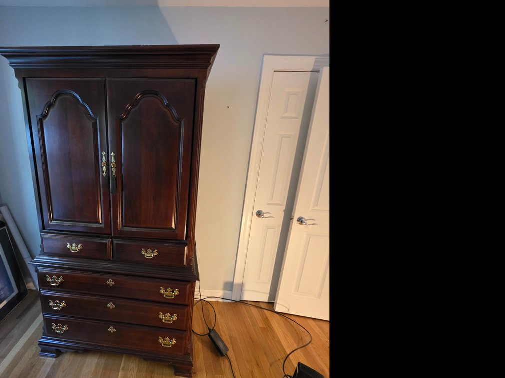 Traditional dark wood media armoire featuring brass-toned pull handles and an open upper compartment