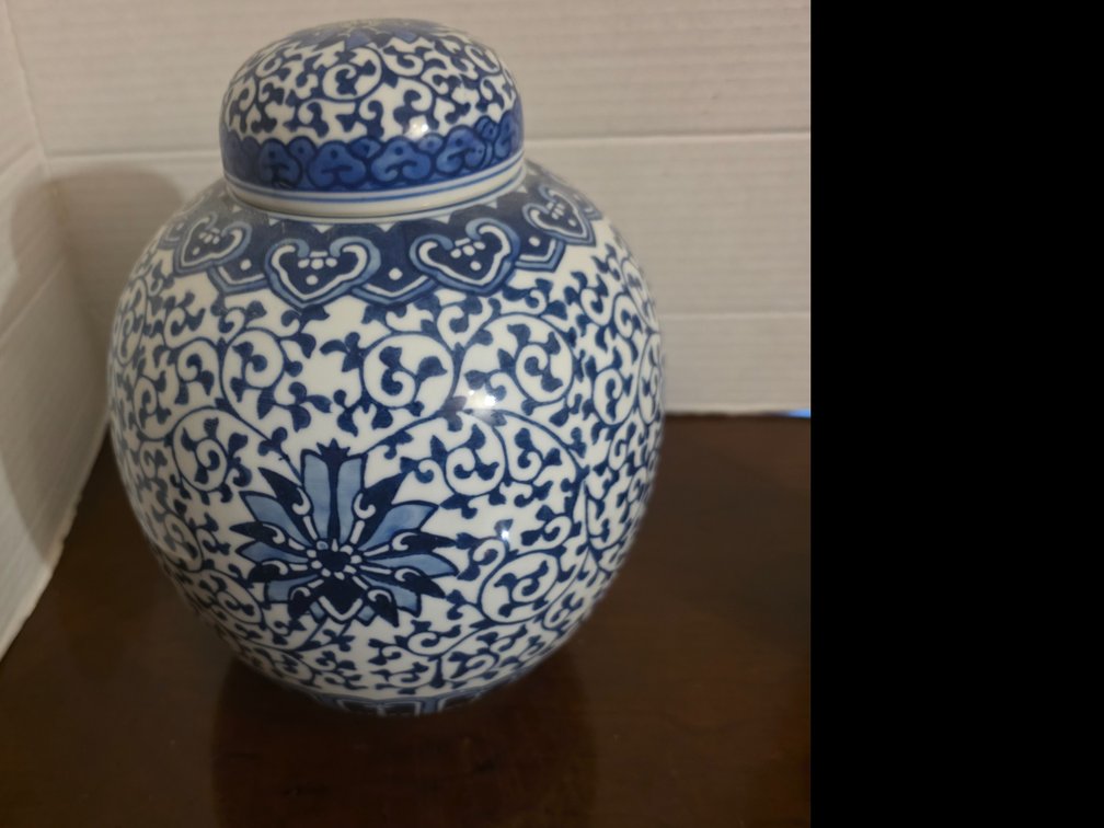 Blue and white porcelain ginger jar featuring a detailed central starburst floral pattern and an ornate patterned lid