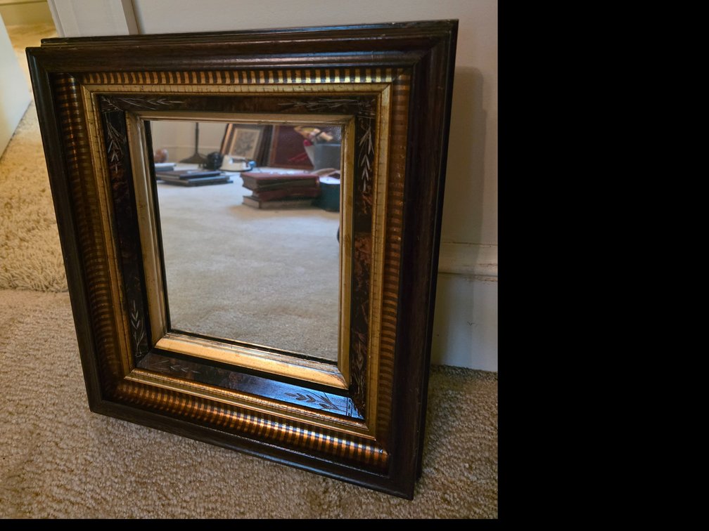 Victorian-style wooden wall mirror featuring a deep, multi-layered dark wood frame with a delicate inlaid motif and a gilded inner border