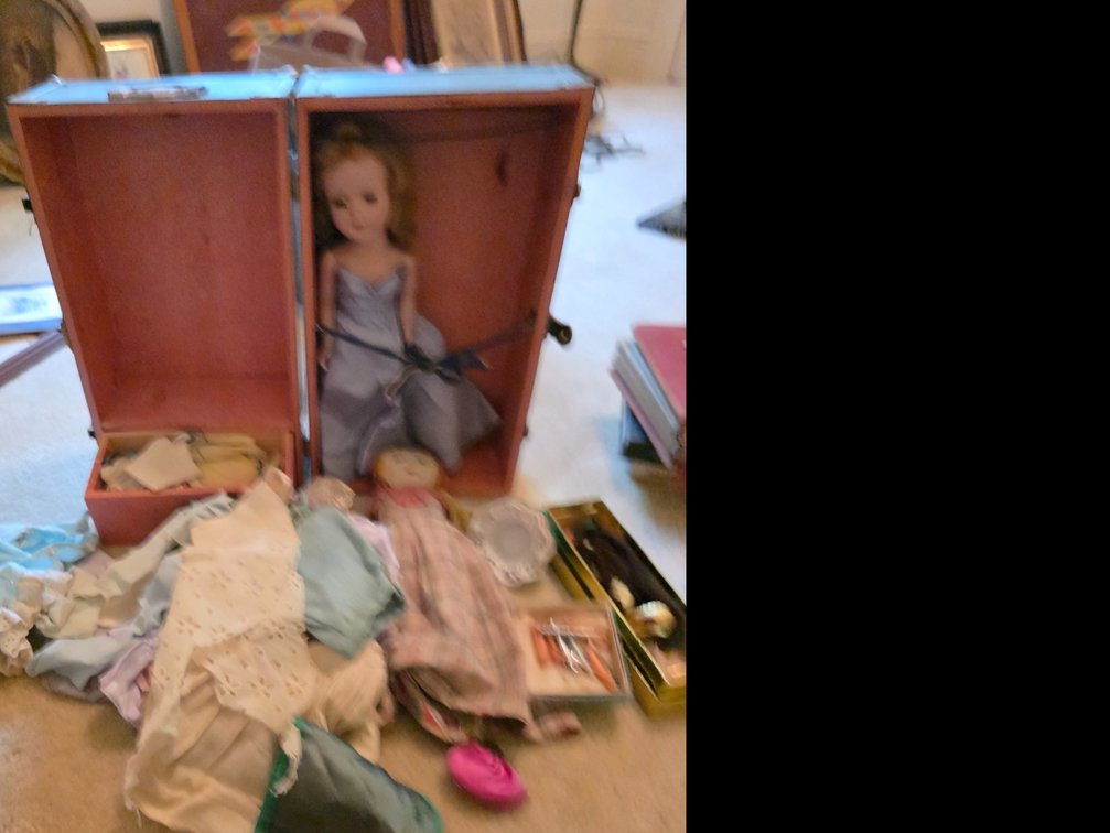 Vintage   doll in a toy wardrobe trunk, including pile of doll clothes and a cloth doll.