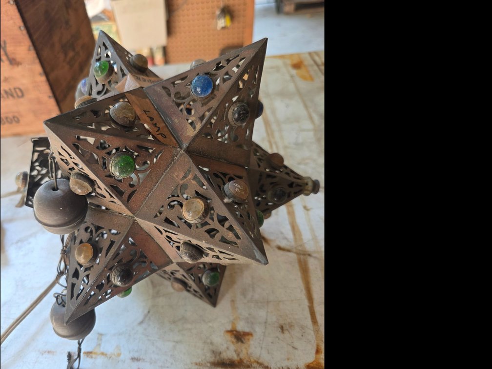 Moroccan-style pierced metal star lamp adorned with colorful glass marbles.