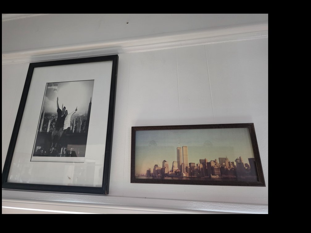 Two people posing on The Beam experience at the Top of the Rock Observation Deck in Rockefeller Center, New York:  vintage pre-9/11 photographic print or poster of the New York City skyline