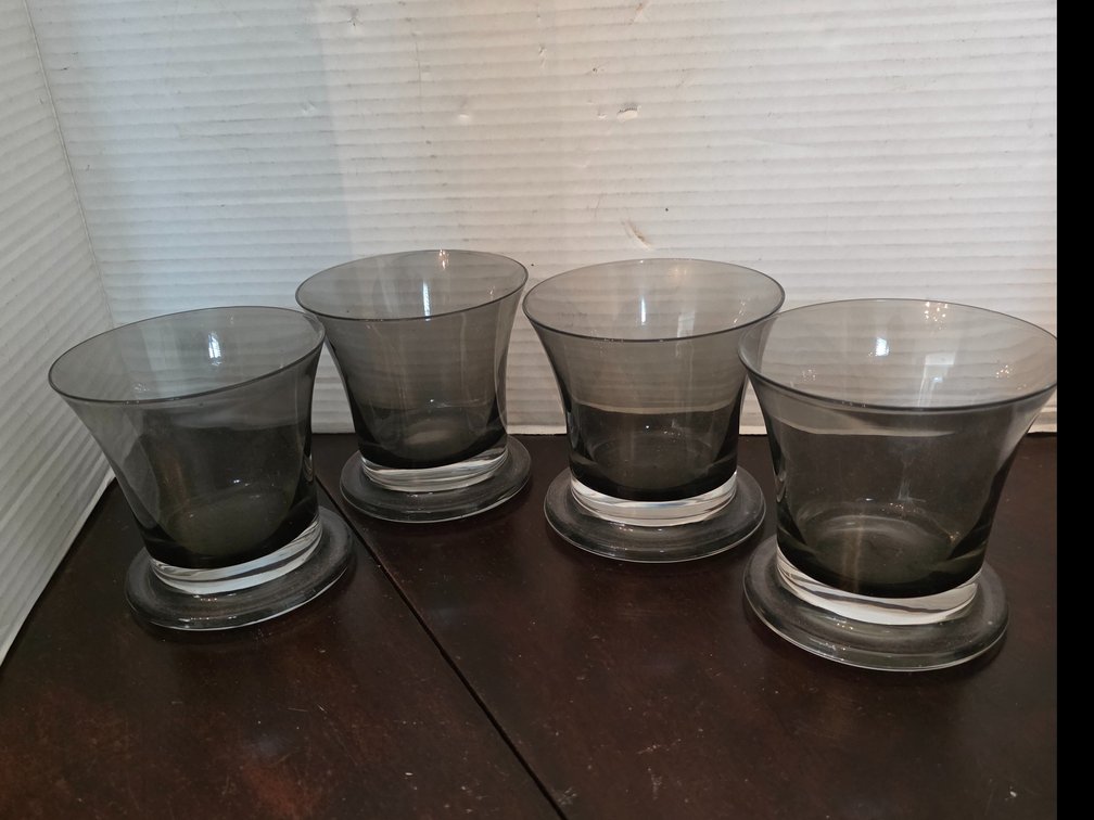 Smoke-gray flared glass tumbler or cocktail glass with a thick clear circular footed base