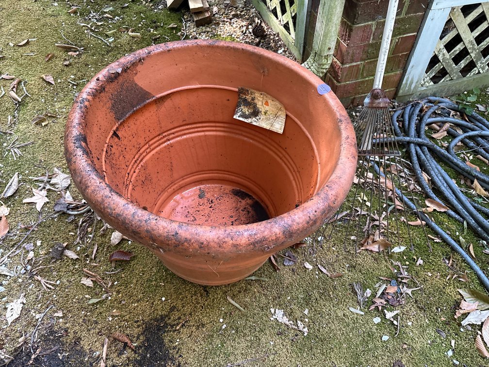 Large plastic terra cotta-style garden planter pot and rake