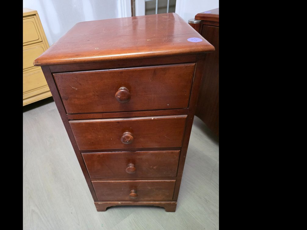 Continental Superior Quality Narrow wooden bedside chest featuring four graduating drawers with simple round wooden knobs.
