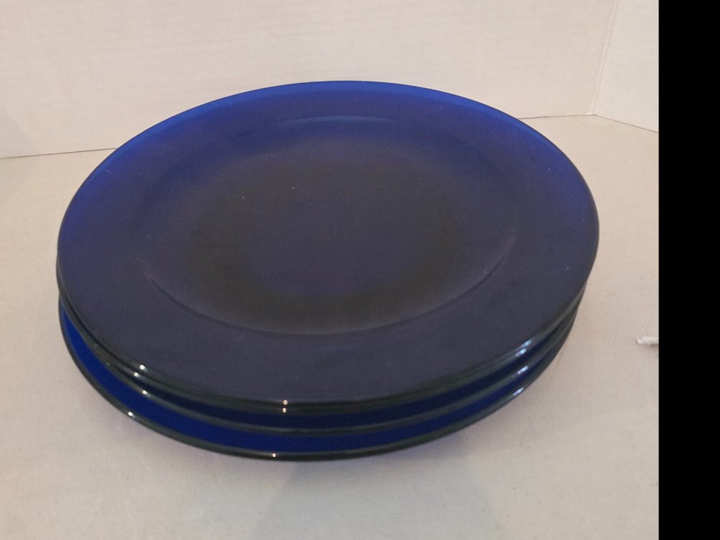 Vibrant cobalt blue glass plate with a smooth, recessed center and a wide rim,