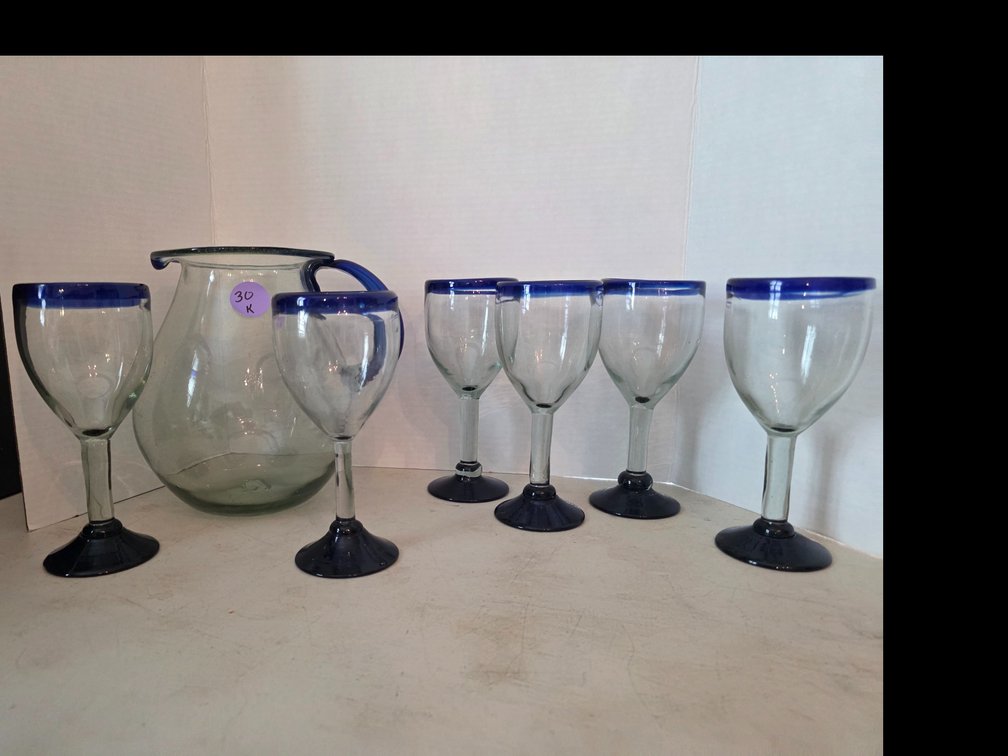 Mexican hand-blown recycled glass pitcher featuring a clear body with a contrasting cobalt blue handle and rim and matching  Wine Glasses Glass