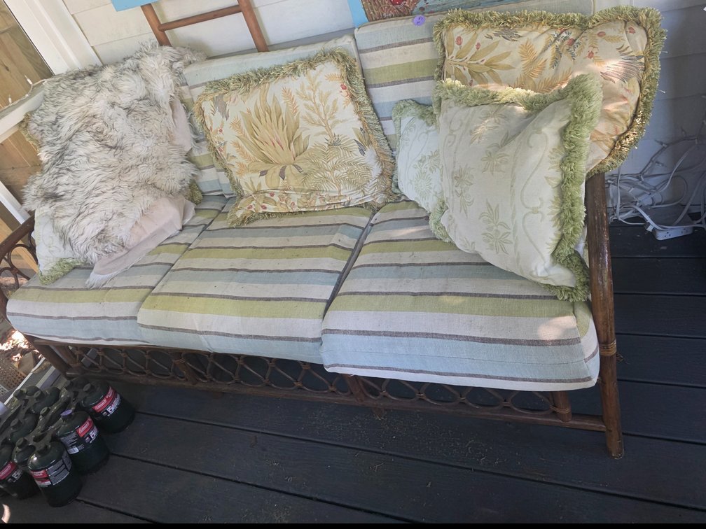 Vintage-style wicker and rattan sofa  and Chair with distinctive circular lattice side frame paired with relaxed green and cream striped cushions.