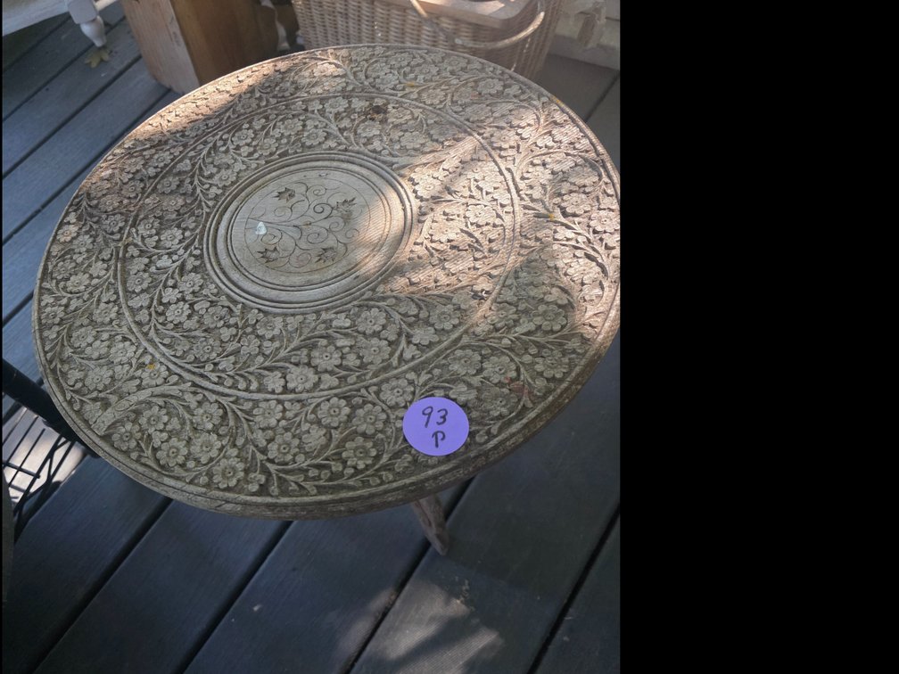 Vintage, hand-carved wooden folding accent table with intricate floral carvings and a central inlay,
