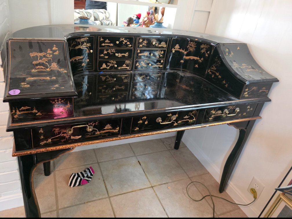 Elegant harpsichord-style desk features a glossy black lacquer finish adorned with intricate hand-painted gold Chinoiserie landscape artwork
