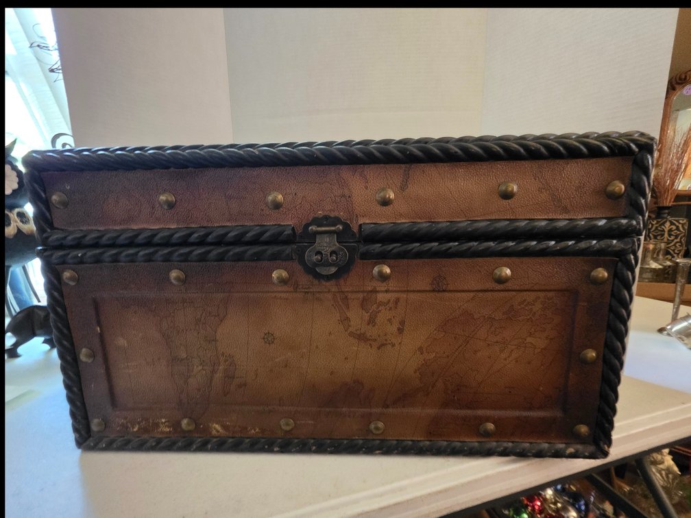 Vintage-style decorative wooden or faux-leather storage chest/trunk featuring a world map print, decorative brass-tone studs, a paneled top, rope-twist trim accents, and a central metal latch.