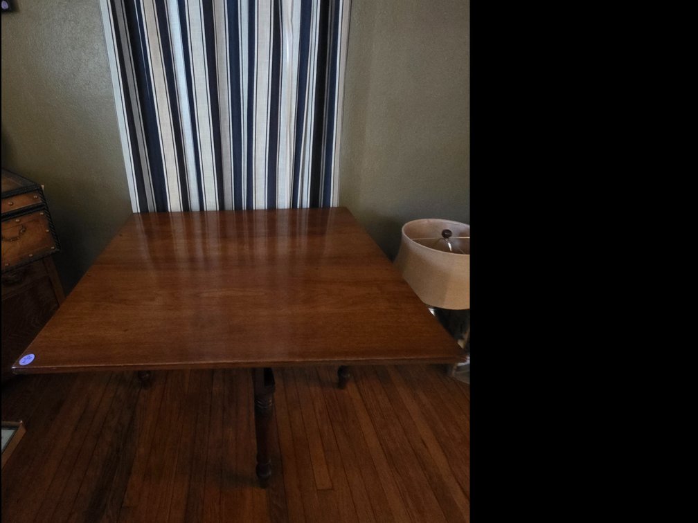 Wooden drop-leaf gateleg dining table with turned legs.