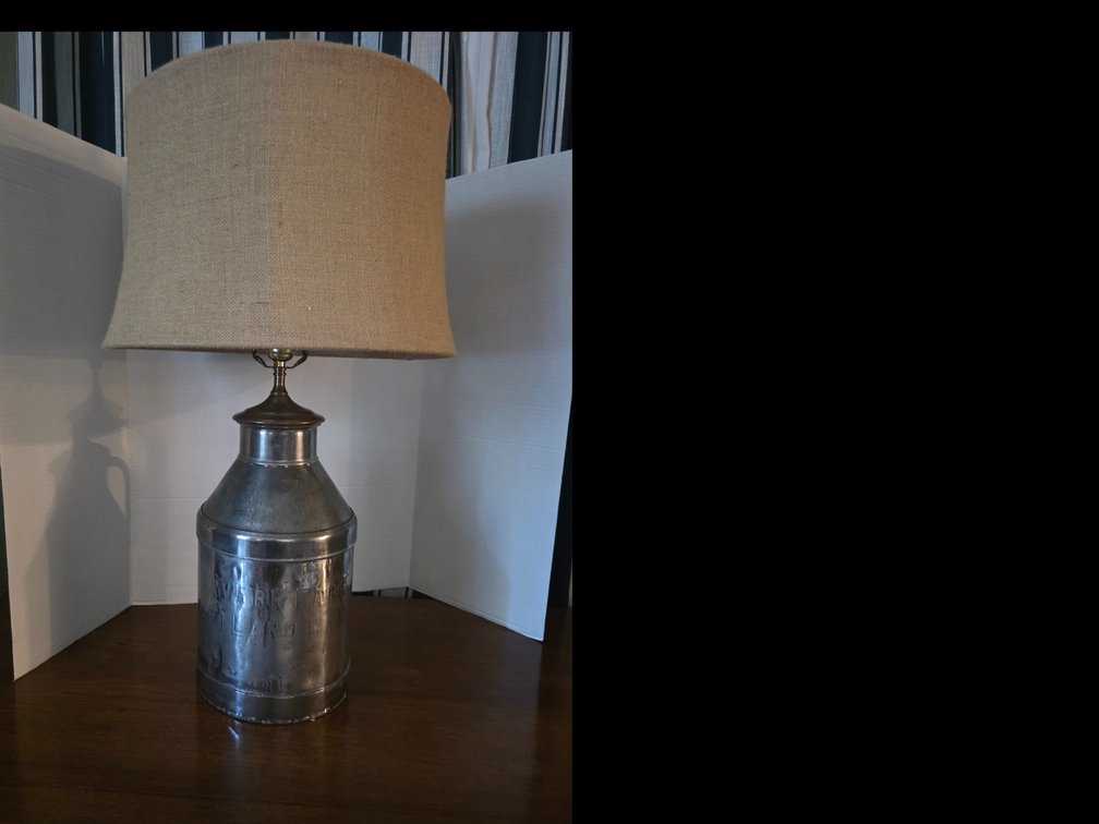 Galvanized metal milk can/jug table lamp topped with a neutral burlap or fabric shade