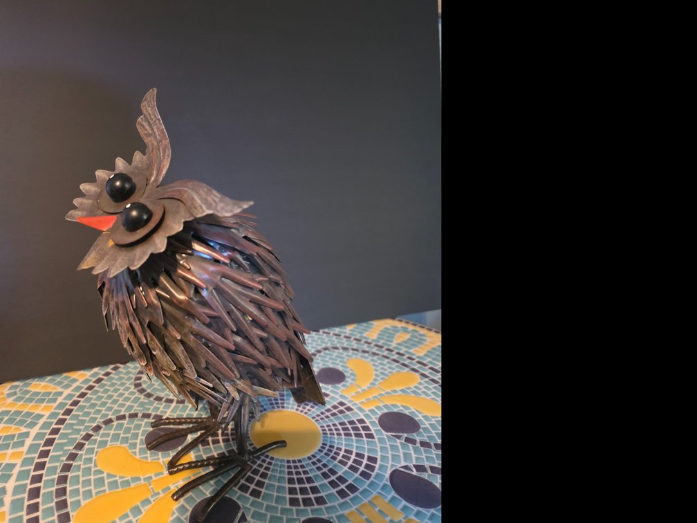 Owl accent sculpture crafted from textured, overlapping metal and iron pieces,