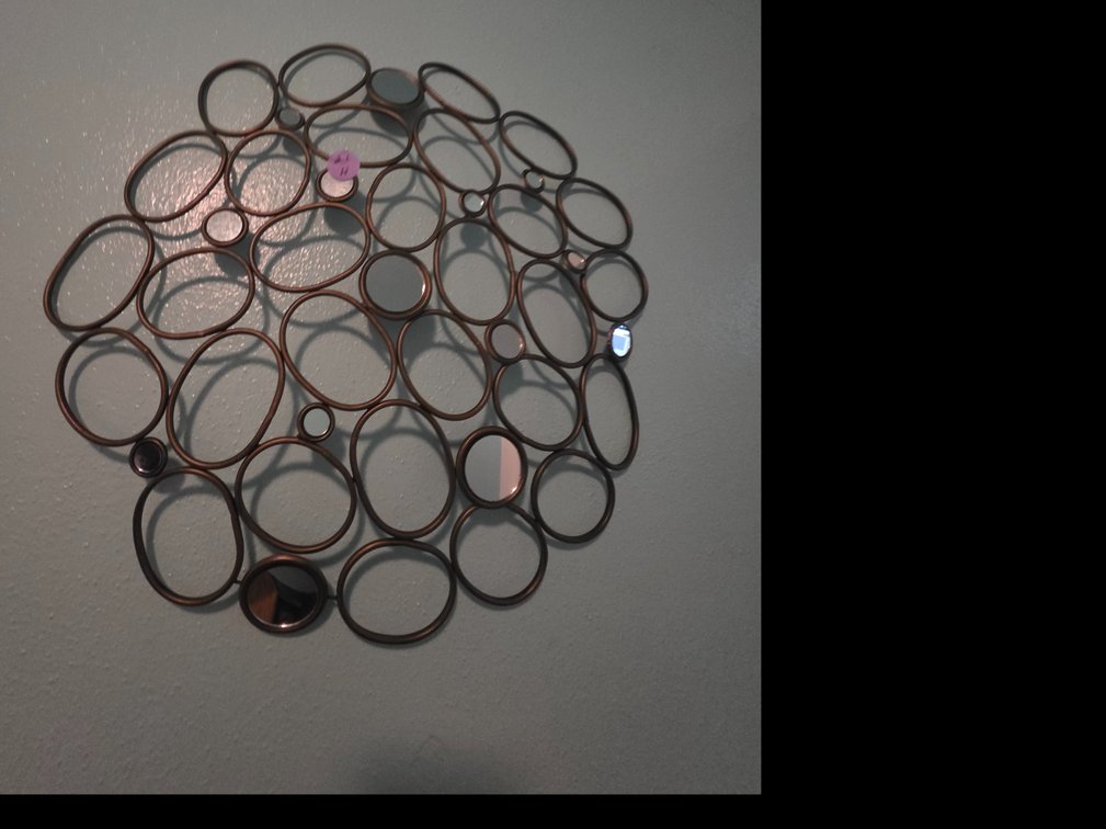 Round metal wall art and mirror sculpture featuring an arrangement of interlocking rings and ovals with small mirrored