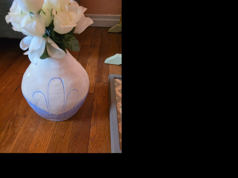 Bulbous white ceramic vase with a light blue bottom portion and hand-carved blue-lined