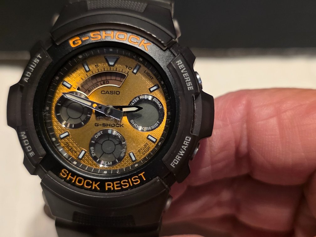 Casio G-Shock AW-591TM-1A analog-digital watch featuring a distinctive yellow/gold face