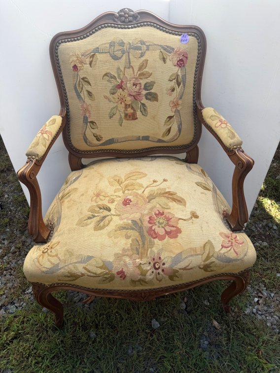 French Louis XV-style carved walnut (or fruitwood) fauteuil armchair featuring floral needlepoint upholstery.