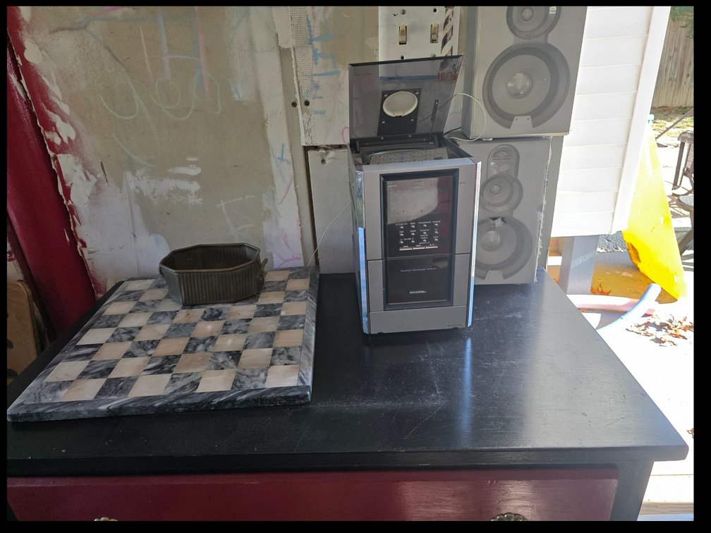 Stone chess and checkerboard,silver vertical-loading compact component stereo system with a top CD lid, central control panel, cassette slot,