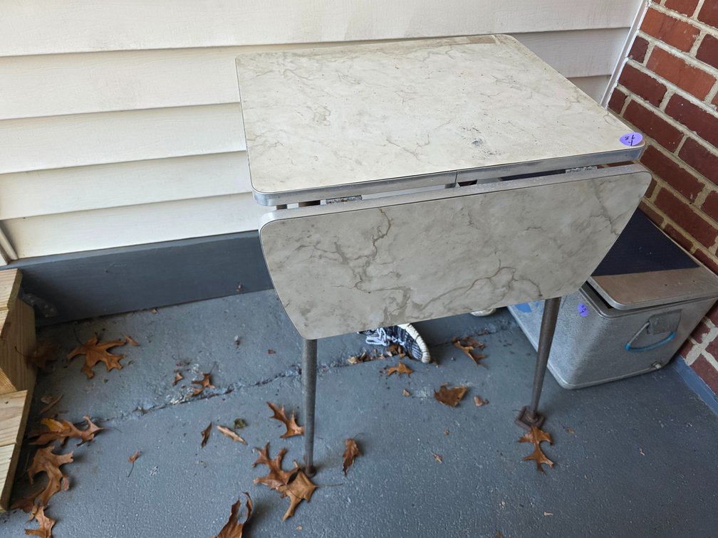 Mid-century drop-leaf kitchen or dinette table with a marbelized/faux-wood Formica top and chrome legs.