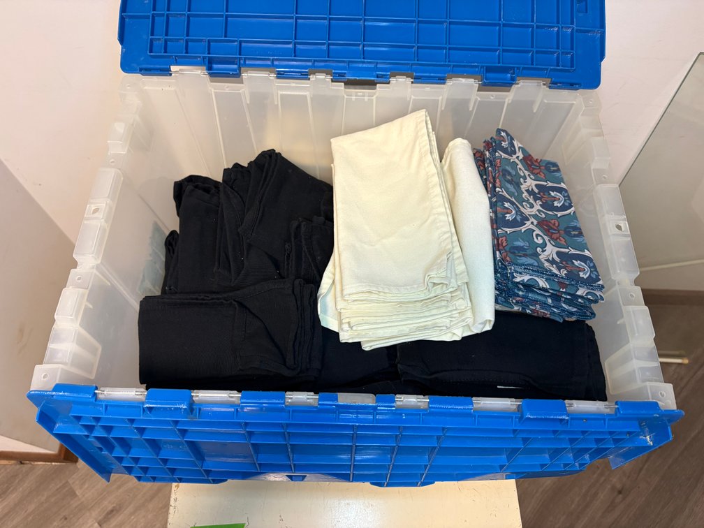 Assorted Linens and Textiles in Blue Industrial Storage Crate