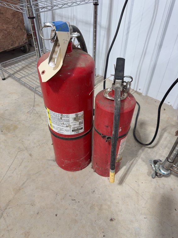 2 Red Portable Fire Extinguishers With Hoses and Pull Pins
