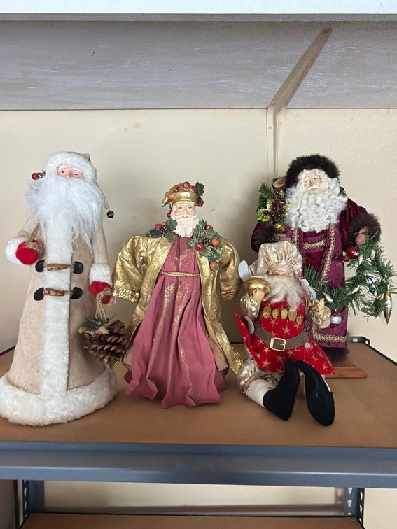 Four Santa Claus Figurines in Festive Robes, Various Styles and Sizes
