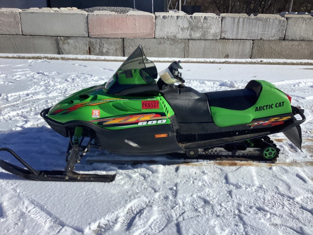 1999 Arctic Cat ZR 600 snowmobile, shows 3,694 miles, registration.