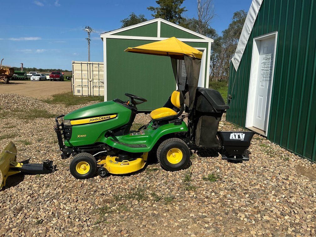 John Deere X300 lawn tractor with bagger, snowblade, seeder, chains