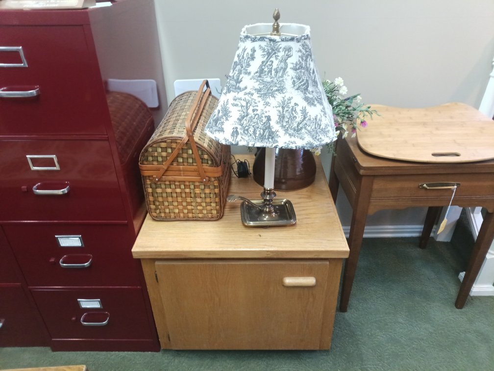 Wooden Two-Tier Cabinet with Victorian-Style Lamp, Woven Basket & Floral Décor