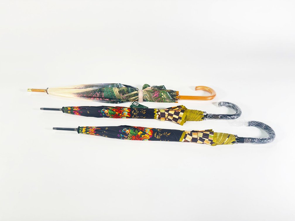 Lot of two MacKenzie-Childs wood handle Umbrellas and a Thomas Kincade umbrella. 