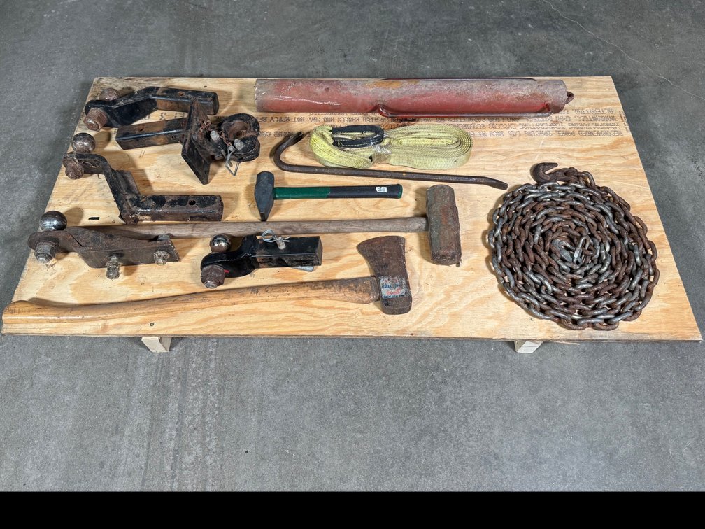 Lot of hanging post driver, receiver, hitches, hammers, toe strap, and log chain.
