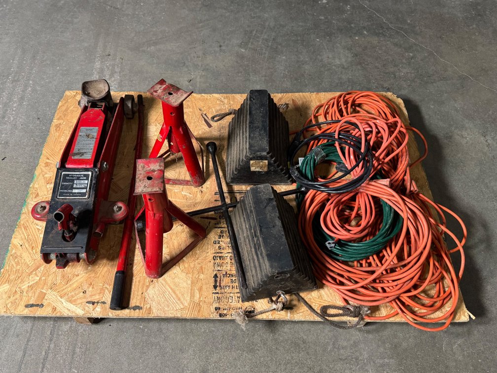 Pair of jackstands, rubber wheel chucks, 3000 pound trolley floor, jack, tire iron, and six electrical extension cords.