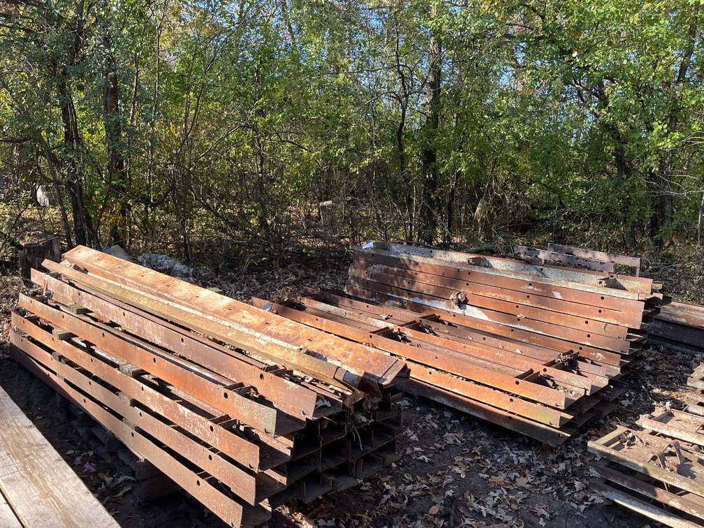 (5) Large Stacks of Concrete Curb Forms