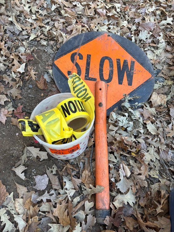 Bucket of Caution Tape and Hand Held Flagging Stop Sign