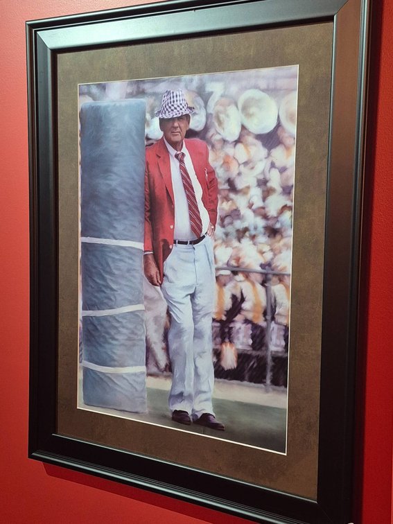 Framed Print of a Man in Red Jacket and Plaid Hat