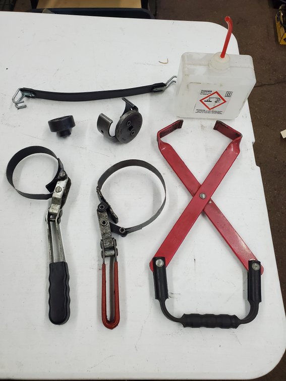 Lot 99: Automotive Specialty Tool Lot Oil Filter Wrench Battery Carrier Strap