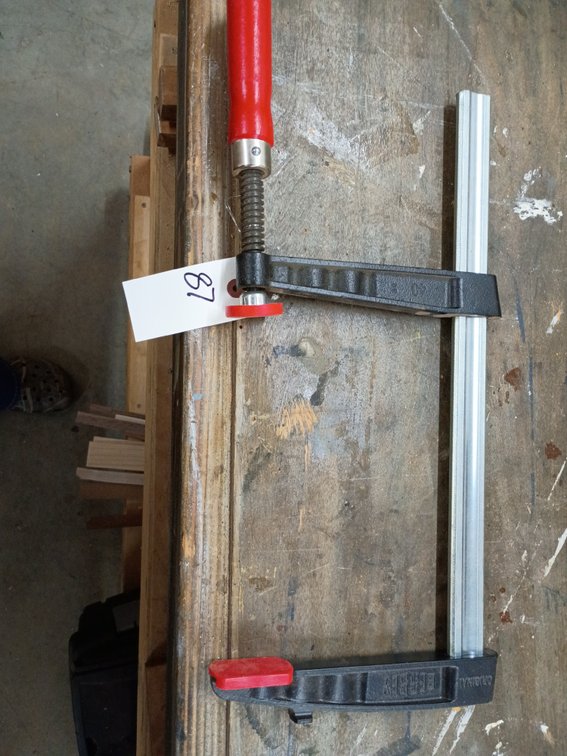 Bessey malleable cast iron screw clamp (F-clamp) with a red wooden handle and profiled steel rail.