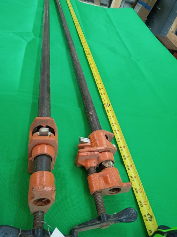 2 Pony 3/4-inch pipe clamp fixtures (such as the Pony Style 50) mounted on metal pipes, commonly used for woodworking and panel gluing