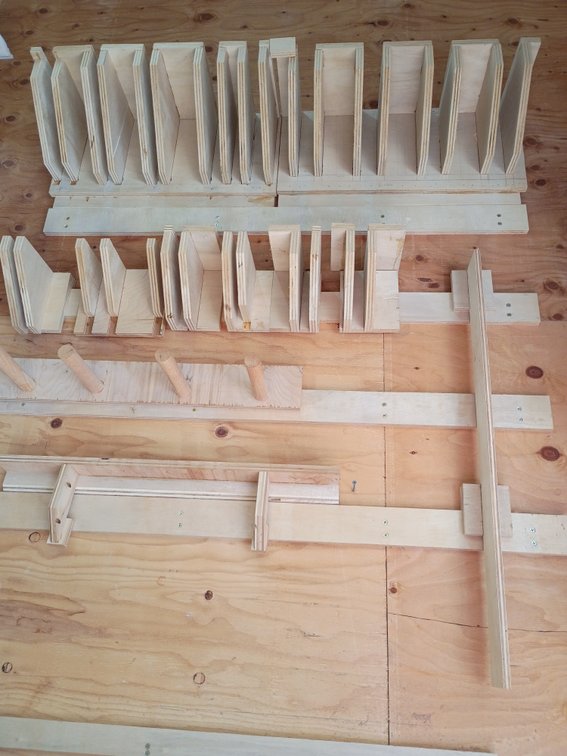 DIY plywood clamp racks mounted on a workshop wall to organize bar, pipe, or quick-grip clamps
