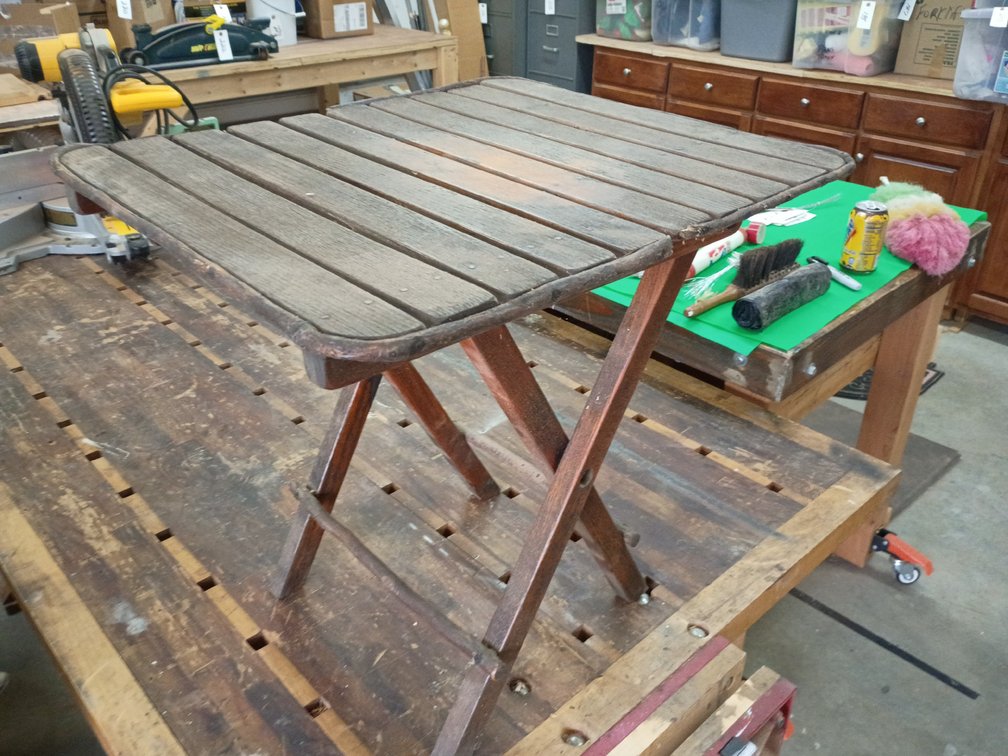 vintage wooden slatted folding table with a dark reddish-brown finish.