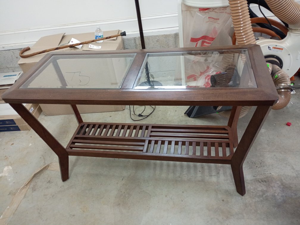 dark cherry finish wooden coffee table with a glass top and a lower slatted shelf, closely resembling the Virginia Beach Coffee Table by Furniture of America