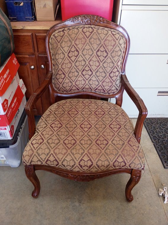 traditional French-style carved wood accent armchair featuring a high back, cabriole legs, and patterned damask or tapestry upholstery