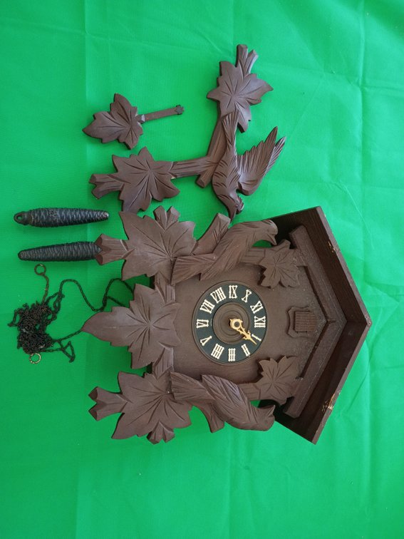 Needs some work. vintage carved wooden Black Forest cuckoo clock featuring leaf accents, Roman numerals, and a top bird carving, likely made in Germany