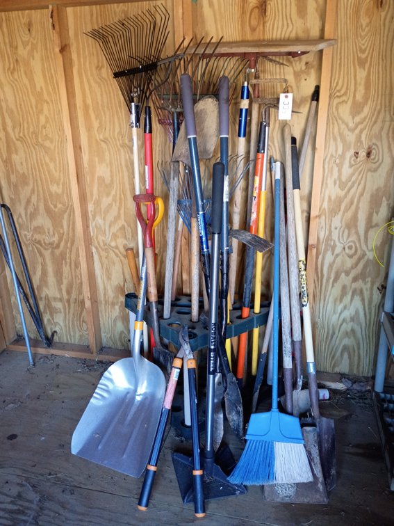 Variety of rakes shovels garden tools with rack