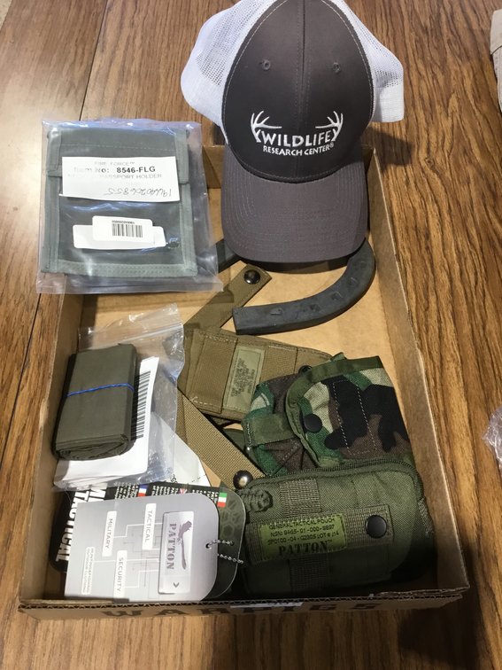 A variety of military surplus gear, tactical pouches, And a baseball style cap