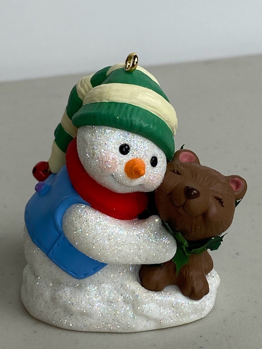 Hallmark Snow Buddies 2002- Snowman has a Blue shirt and green and white hat, hugging a brown dog -No box